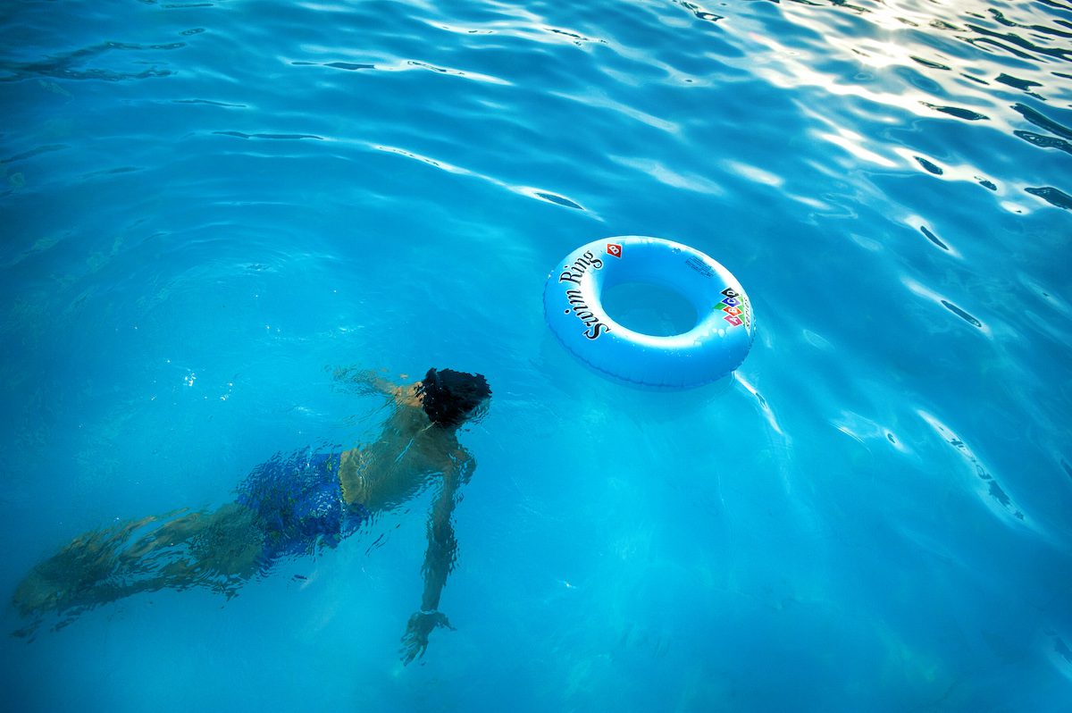 person swimming under body of water near blue inflatable 1540297 1