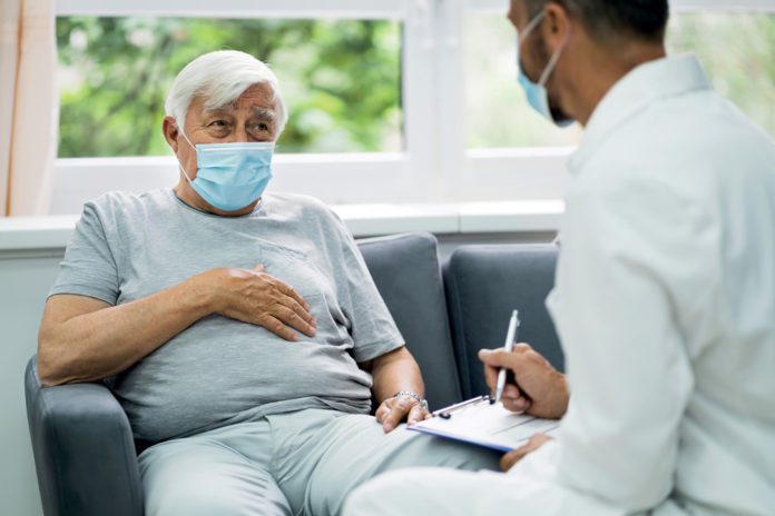 Doctor Talking To Elderly Patient At Home