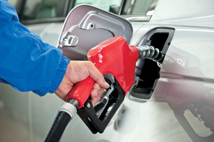 Hand Pumping Gasoline From Red Fuel Pump Nozzle