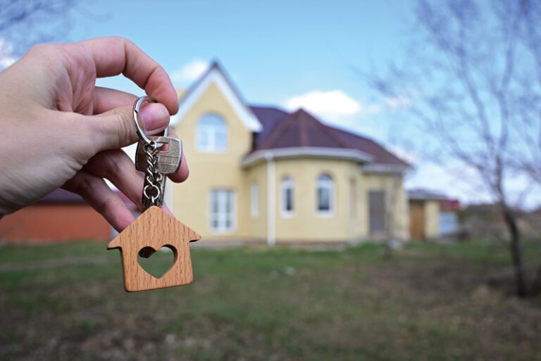 A woman holds the key to a new house in her hand. Mortgage loan approval housing loan
