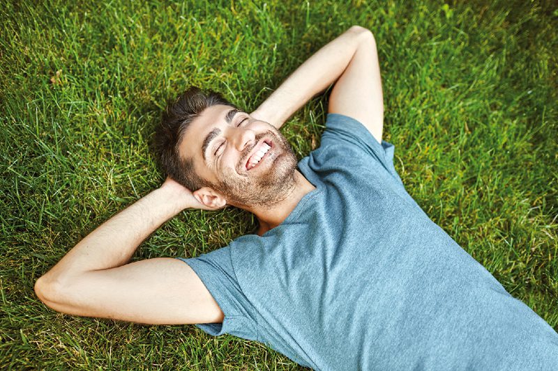 Hombre feliz acostado en grama 