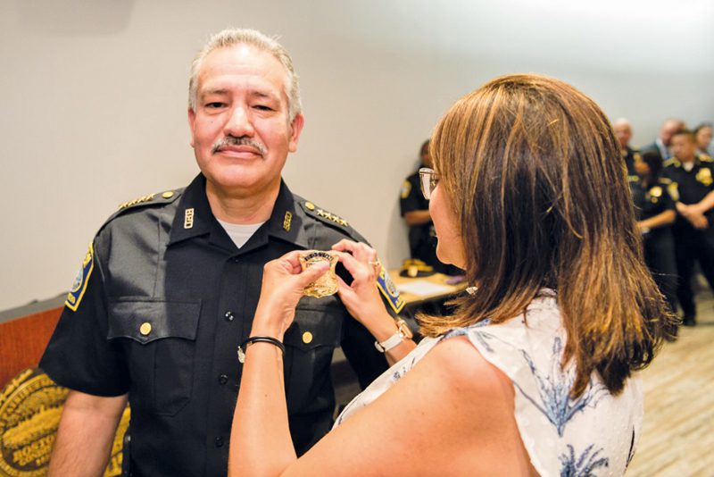 El oficial Luis Cruz recibe de manos de su esposa la insignia de ascenso a Superintendente.