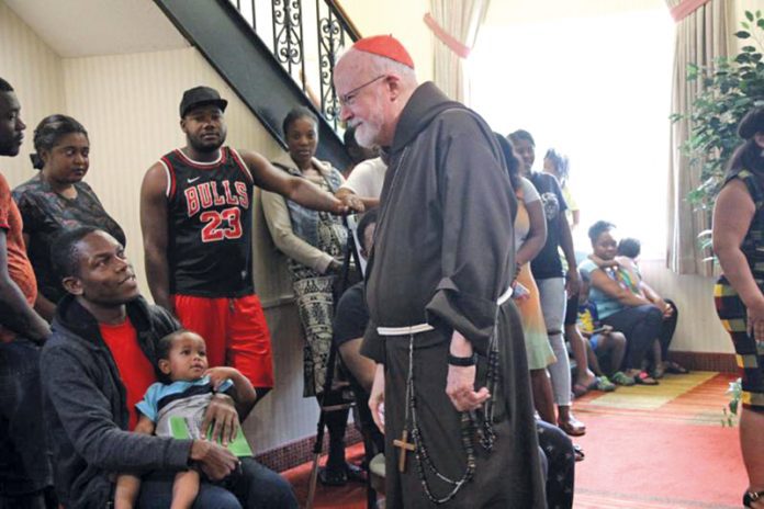 Cardinal O’Malley welcomes new arrivals at the newly opened shelter. Pilot photo/Jacqueline Tetrault