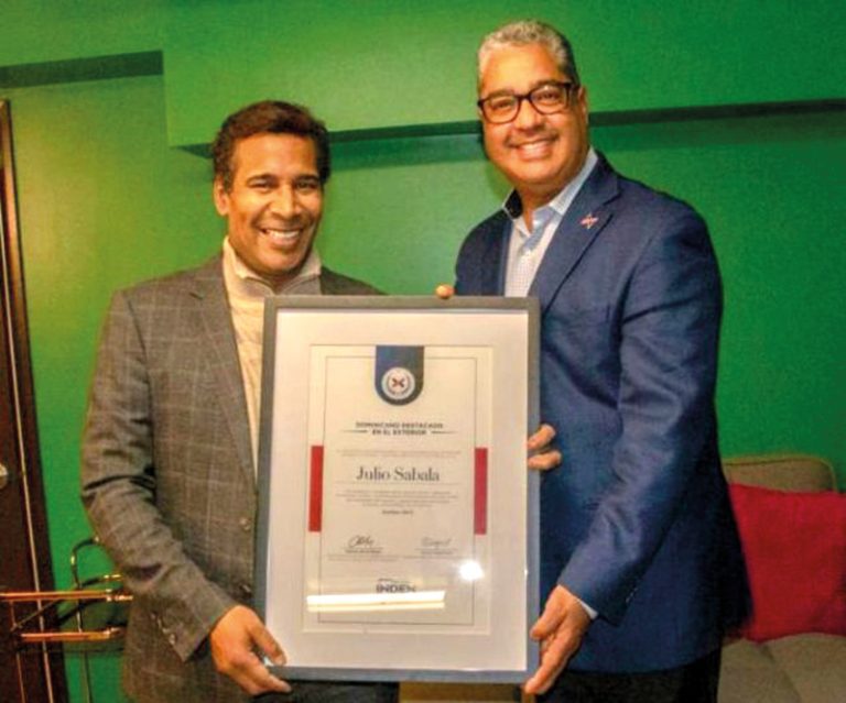 Director de INDEX-Boston entrega placa de reconocimiento a artista dominicano.