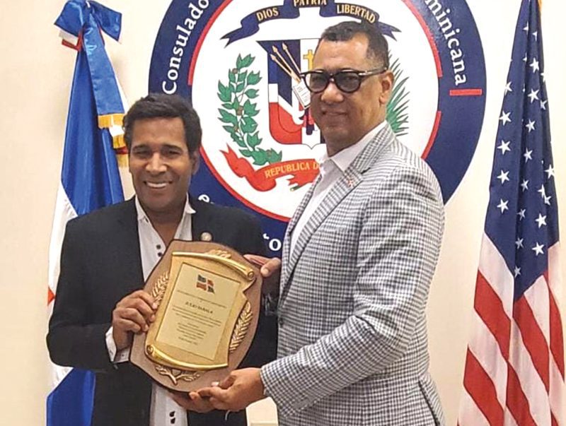 Julio Sabala recibe reconocimiento de manos del Cónsul dominicano.