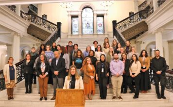 En el State House: La directora ejecutiva de Massachusetts Health Connector, Audrey Morse Gasteier, habla sobre la disponibilidad de ayuda para la inscripción de las organizaciones locales de Navigator, en la Grand Staircase de la Casa del Estado de Massachusetts el 13 de enero. Morse Gasteier estuvo acompañada por más de 30 representantes de 15 organizaciones de Navigator en el evento.