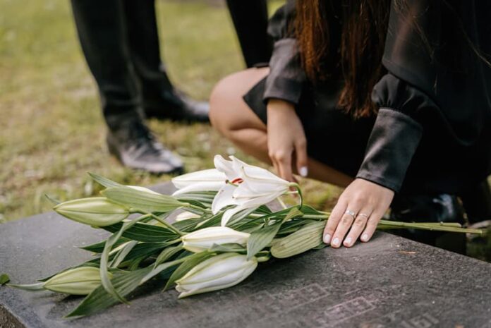 Mujer poniendo flores en tumba