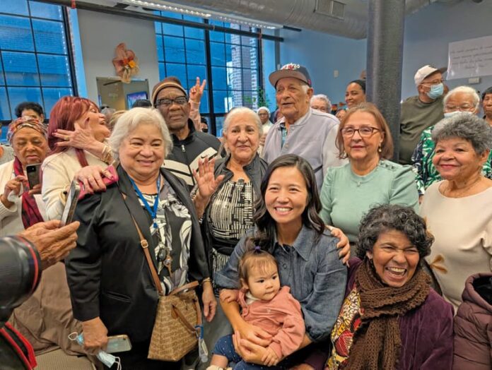 Con su bebé Mira en brazos, alcaldesa Michelle Wu disfruta con los adultos mayores.