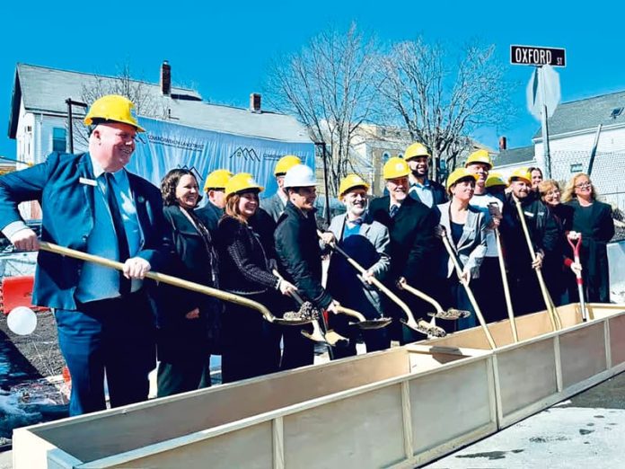 Alcalde de Lynn, Jared Nicholson, en medio de autoridades dando el primer palazo para la construcción de apartamentos.