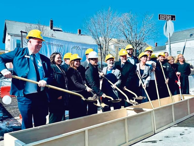 Alcalde de Lynn, Jared Nicholson, en medio de autoridades dando el primer palazo para la construcción de apartamentos.