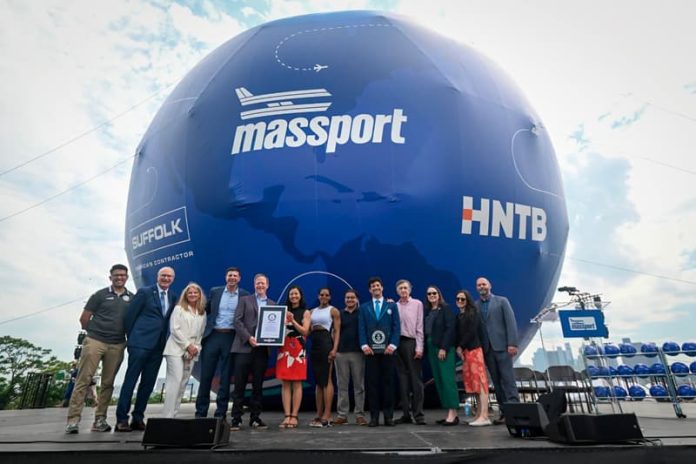 Rodeada de funcionarios de Massport y de otras entidades, Alcaldesa Michelle Wu muestra el título de Guinness como el balón de fútbol más grande del mundo.