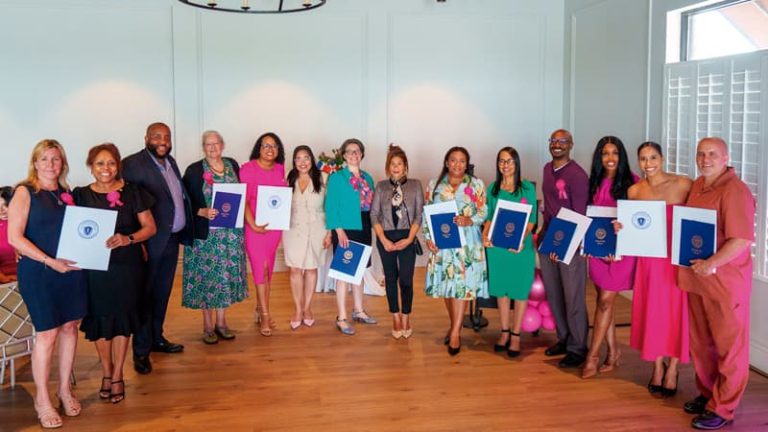 Comenzando a la izquierda: Mónica Young, Glennys Acosta, Representante Estatal Chris Worell, Melissa McWhinney, Yarlennys Villaman, Alexandra Valdez, Geneva Allison, Concejal Julia Mejia, Larissa Amezquita De Guzmán, Delia Díaz, Vladimir Mazarin, Jessica Clergeau, Kati Fernandez y Gregg Croteau.