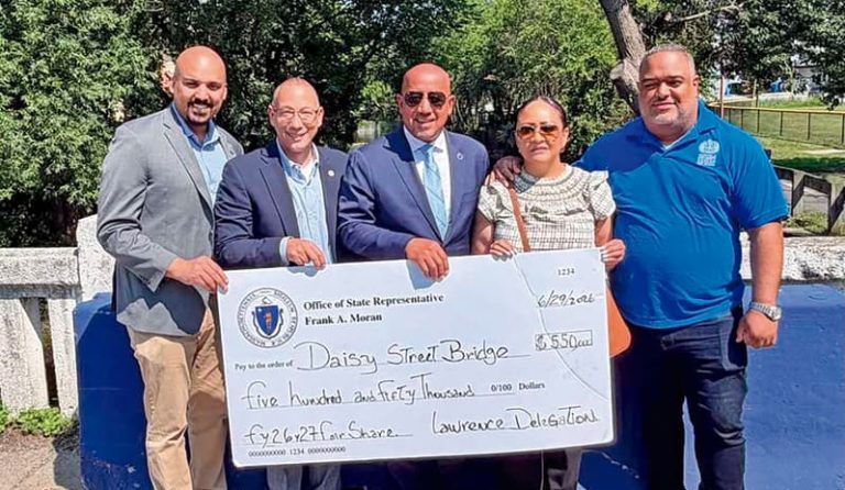 Feliz alcalde Brian de Peña recibe cheque a nombre de la ciudad de manos del Representante estatal Frank Morán rodeados del senador Pavel Payano y de los Representantes estatales, Estela Reyes y Francisco Paulino.