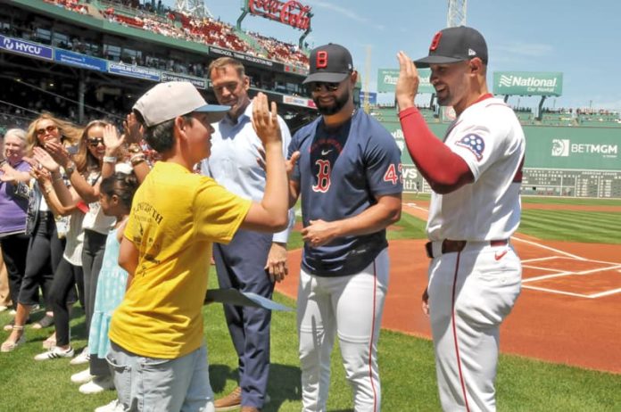 11-Entrega de certificado_13 El Mundo Boston and the Red Sox honored Latino middle school students from Revere Public Schools during the final of three Latino Youth Recognition Days this year. In the photo: Student Maximiliano Uran Berrio is congratulated by Red Sox Players Patrick Sandoval and Jovani Morán.