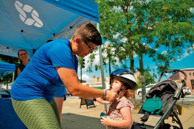 Barbara DiGirolamo, coordinadora del Programa de Prevenci&oacute;n de Lesiones del Hospital Infantil de Boston, le coloca a una ni&ntilde;a de East Boston su primer casco de bicicleta.